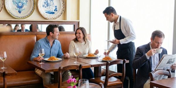 Friends and families enjoying brunch at a cozy Catskills restaurant with wood interiors and natural light.