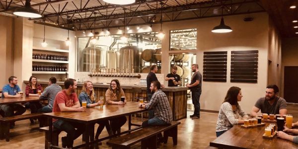 Large wheels and slices of artisan cheese displayed on a wooden counter at a Vermont market