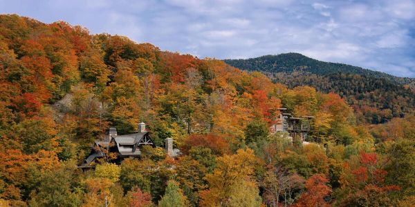 Fall foliage in Stowe, Vermont with colorful autumn trees surrounding mountain homes and rolling hills