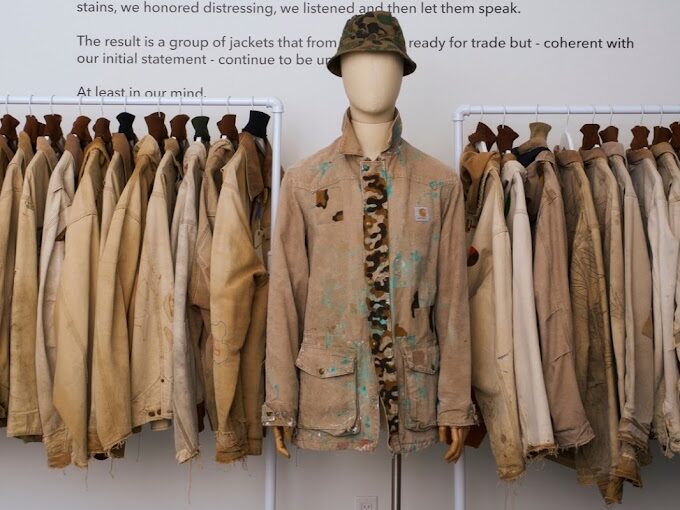 Racks of jackets and a mannequin with a jacket and hat on 