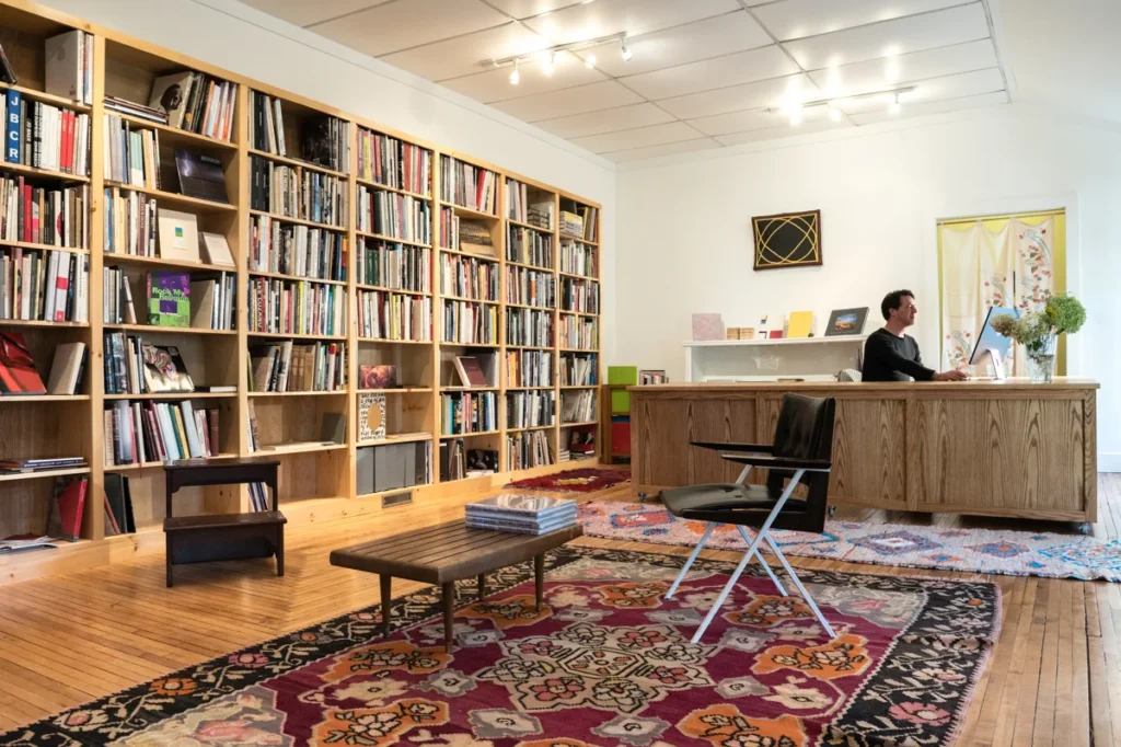 Inside bookstore with shelves and a man sitting at a desk