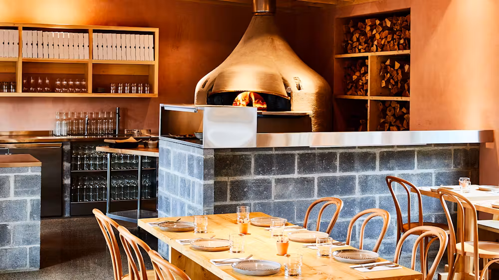 Inside LOLA Pizza, brick oven and seating area