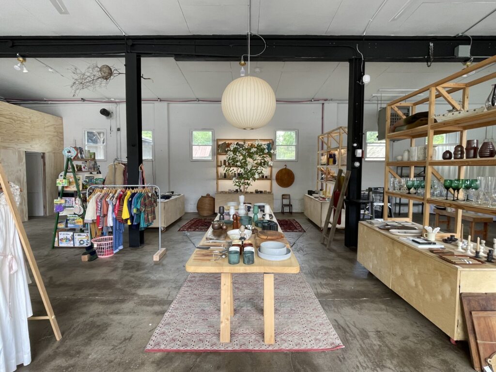 Inside studio with clothes, pottery, and home goods