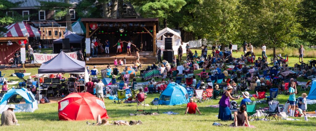 Festival goers spread out on the lawn watching 